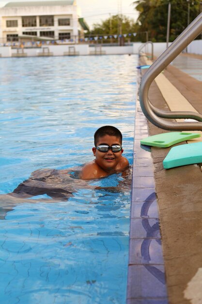 Retrato de un niño sonriente en la piscina