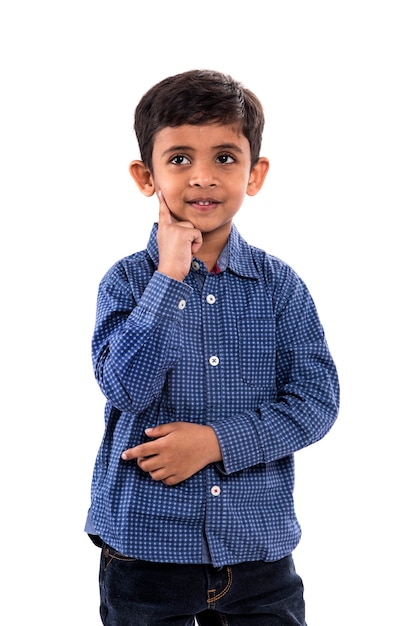 Retrato de un niño sonriente posando sobre un fondo blanco.