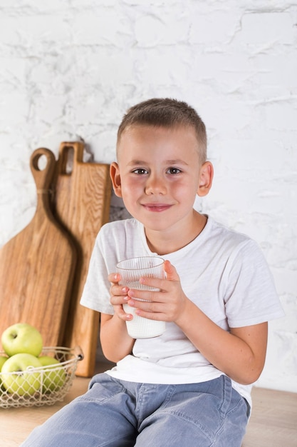 Retrato de un niño sonriente sentado en el sofá en casa