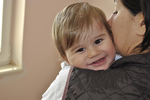 Retrato de un niño sonriente con su madre en casa