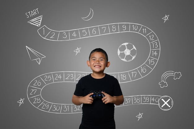 Retrato de un niño sonriente con un videojuego de pie contra un fondo gris