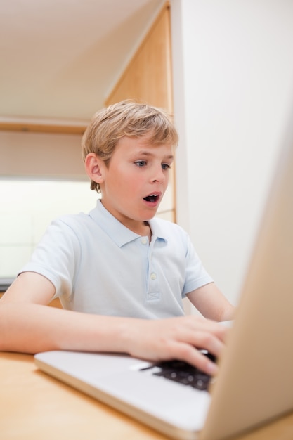 Retrato de un niño sorprendido usando un cuaderno