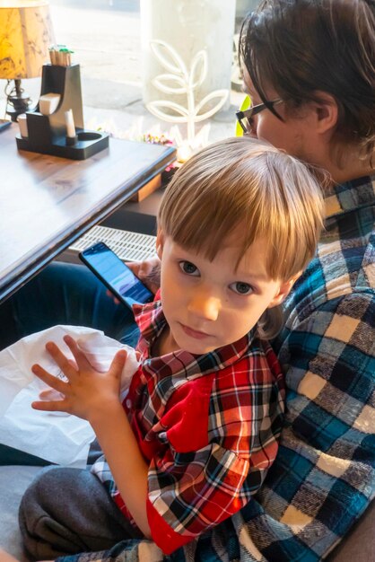 Retrato de niño con su padre dibujando con lápices en cafe