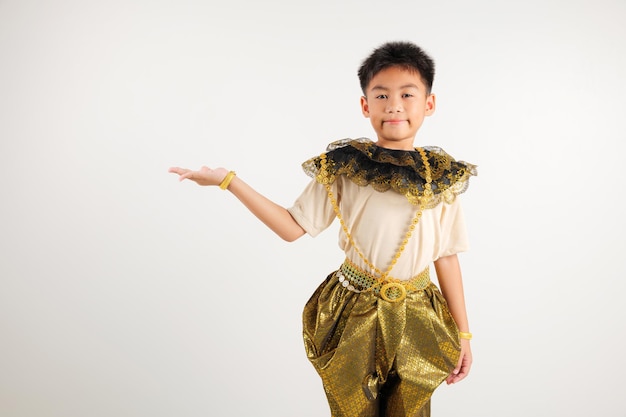 Retrato de un niño de Tailandia sonriendo traje tradicional tailandés presentando un producto sosteniendo algo en la palma de la mano estudio lateral aislado fondo blanco
