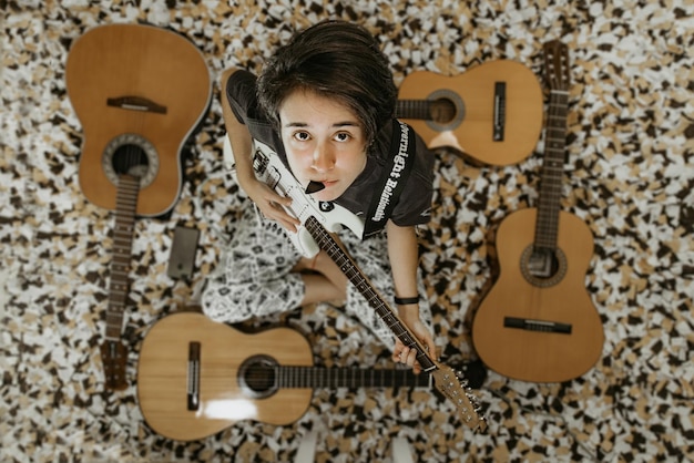 Foto retrato de un niño tocando la guitarra