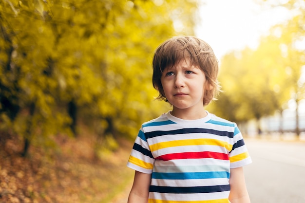 Foto retrato de niño triste en el otoño en la naturaleza caminar al aire libre