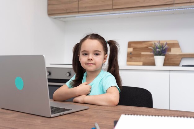 Retrato de un niño usando una computadora portátil mientras está sentado en la mesa