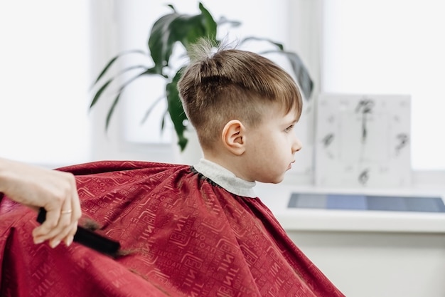 Retrato de niño varón en la peluquería para cortarse el pelo
