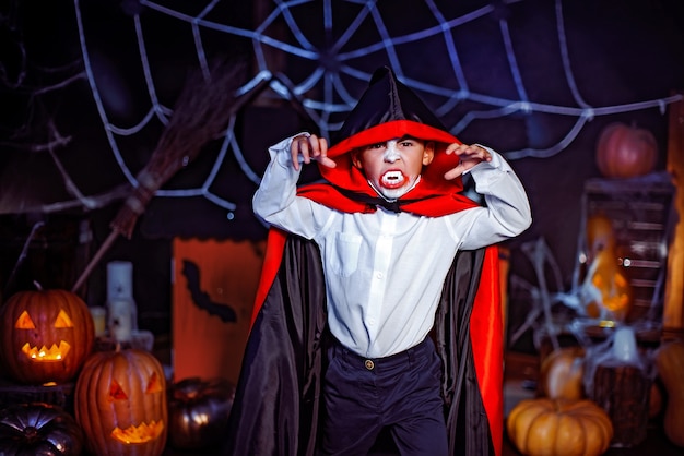 Retrato de un niño vestido con un traje de vampiro sobre fondo grunge. Fiesta de Halloween.