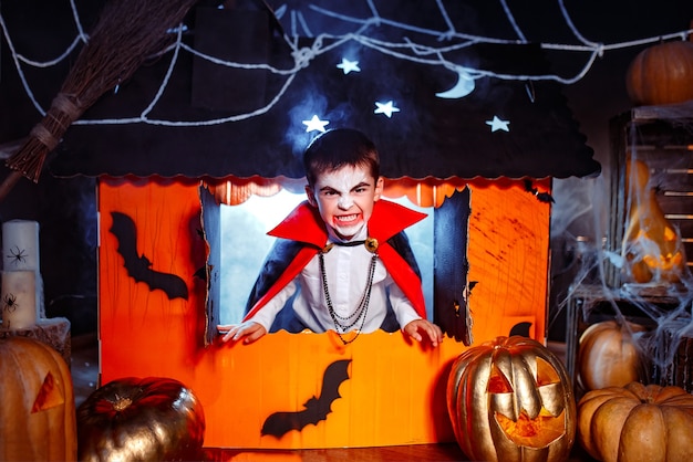 Retrato de un niño vestido con un traje de vampiro sobre fondo grunge. Fiesta de Halloween.