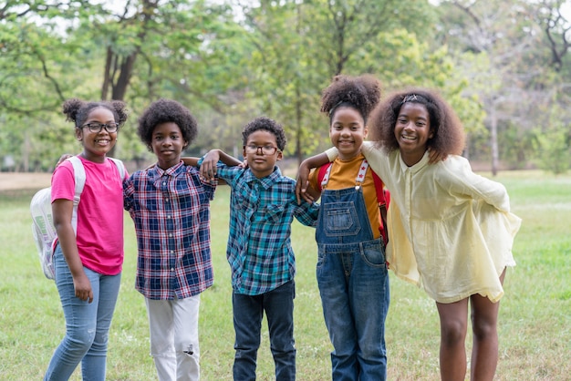 Retrato de niños afroamericanos de pie y mirando en el parque