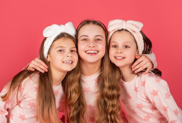 Retrato de niños felices con caras sonrientes en fondo rosa homewear