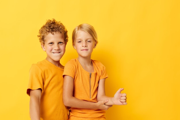 Retrato de niños lindos abrazando moda entretenimiento infantil fondo amarillo inalterado