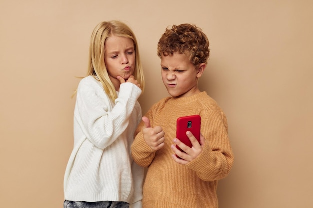 Retrato de niños lindos abrazo entretenimiento selfie posando amistad fondo beige