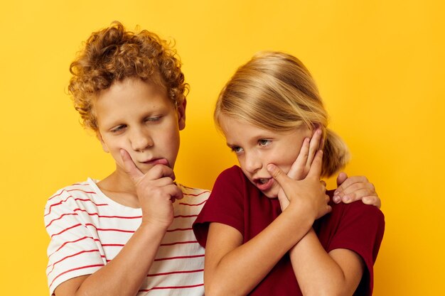 Retrato de niños lindos juegos de ropa casual divertidos juntos sobre fondo de color