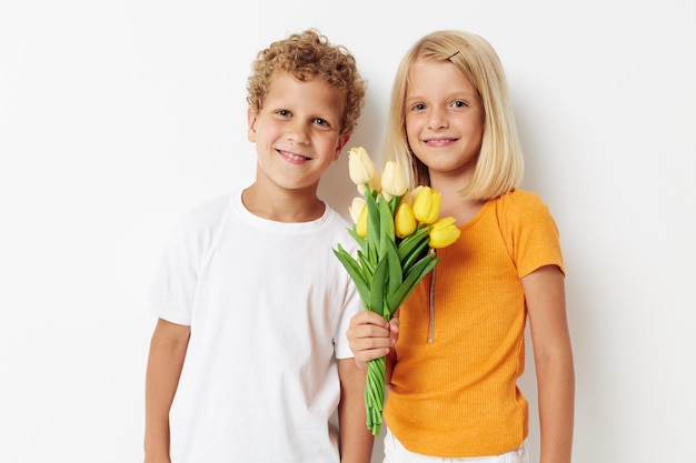 Retrato de niños lindos vacaciones amistad con un regalo flores amarillas estilo de vida inalterado