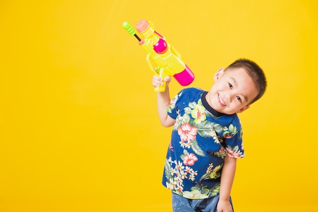Retrato niños niño sonrisa sosteniendo pistola de agua