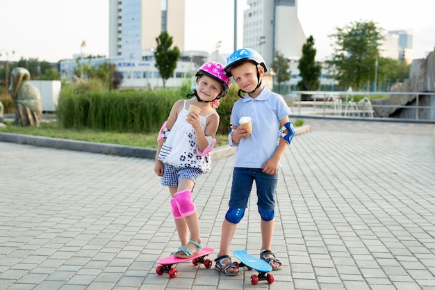 Foto retrato de niños en el parque con patines, comen helado