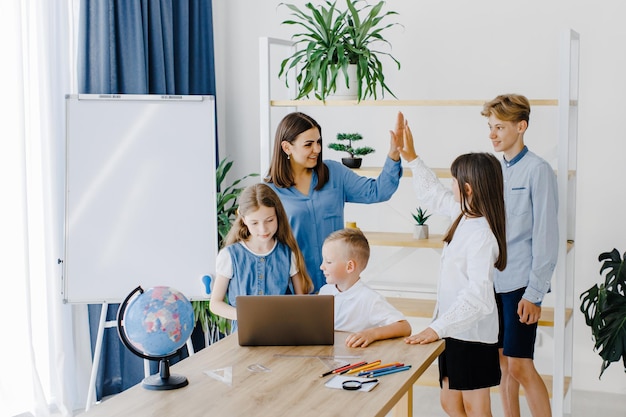 Retrato, de, niños, y, profesor, mirar la computadora portátil, en, el, aula