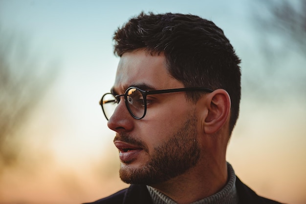 Retrato de noche de un hombre con gafas y barba.