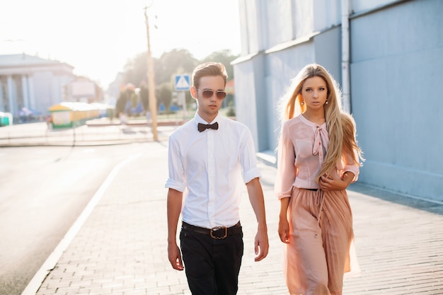 Retrato de noche de verano al aire libre de la elegante pareja joven caminando en la calle