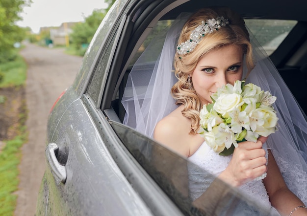 Retrato de una novia bastante tímida en la ventana de un auto