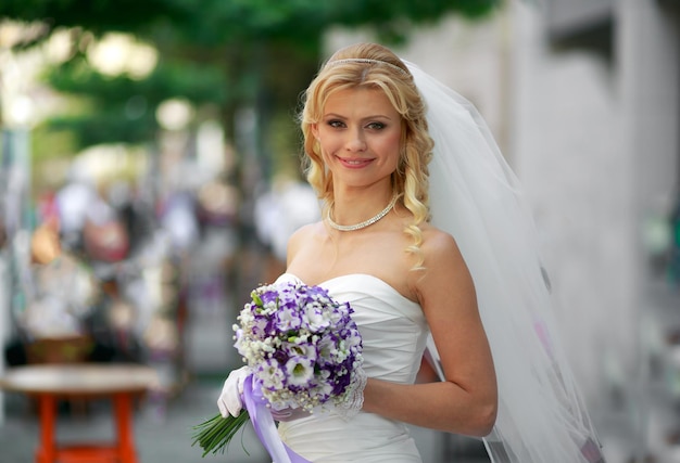 Retrato de una novia feliz con un ramo de brillantes