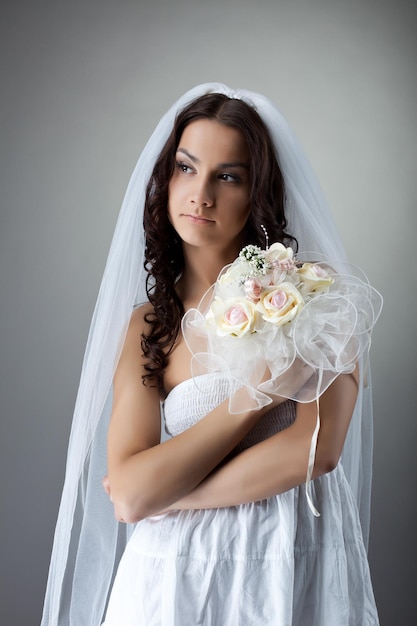 Retrato de novia joven belleza con ramo de flores