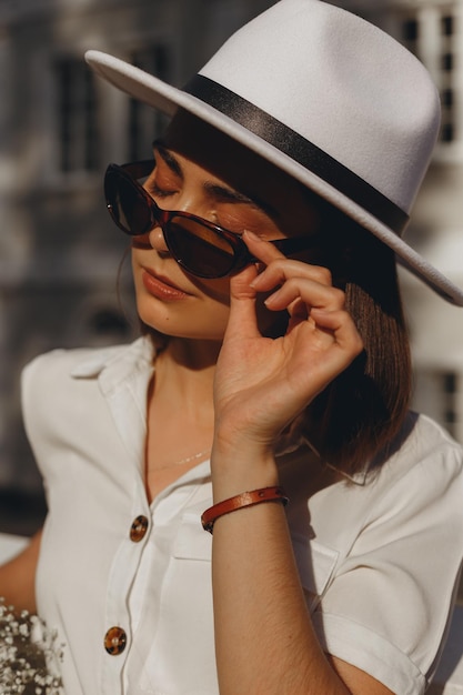 Retrato de novia joven con gafas de sol y sombrero en un día soleado