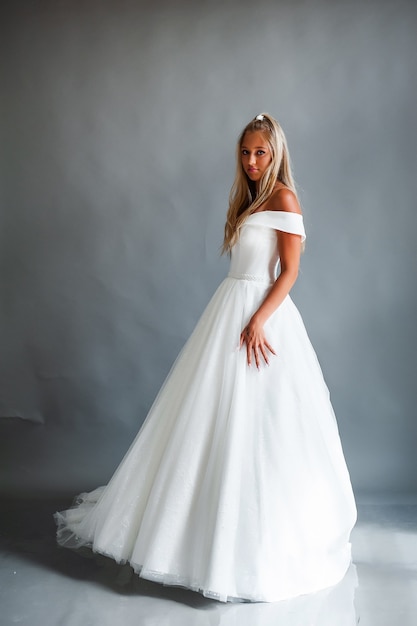 Retrato de novia perfecta de una niña con un vestido largo blanco