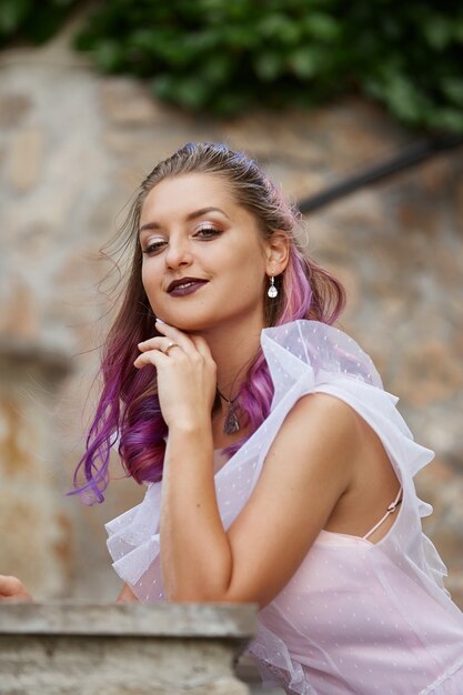 Retrato de una novia con primer plano de cabello morado. Una mujer con un hermoso vestido descansa