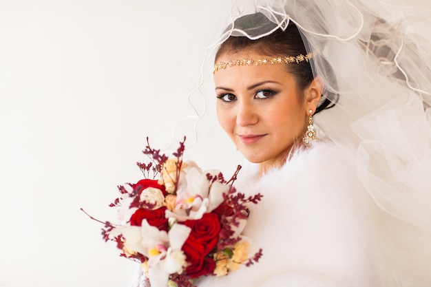 Retrato de novia con el ramo de flores en invierno