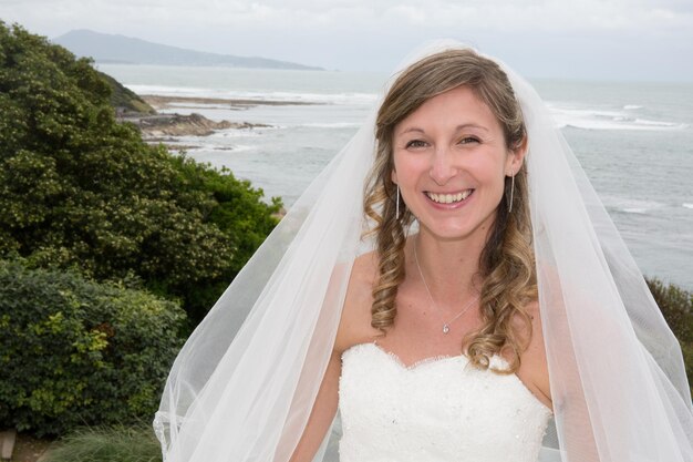 Retrato de una novia rubia en el océano.