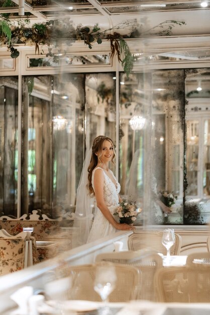 Foto retrato de una novia con un vestido blanco en un café luminoso