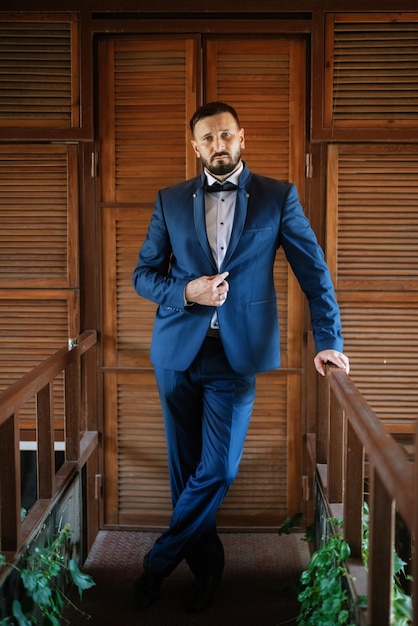 Retrato de un novio con barba en un traje azul