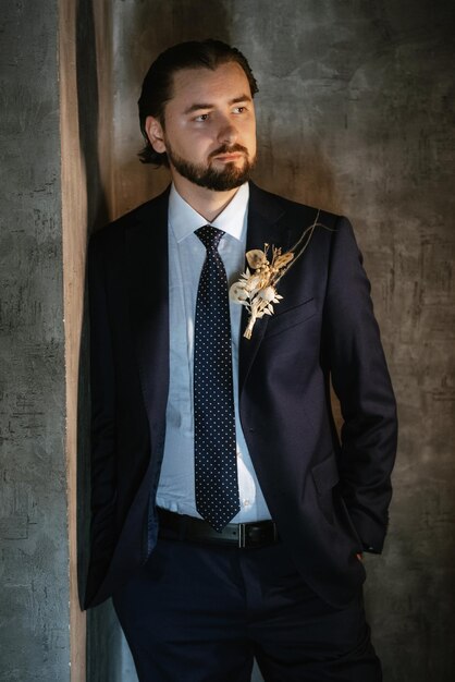 Retrato de un novio masculino con traje azul en la barbería de la mañana