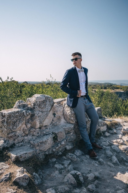 Retrato del novio en las montañas en las montañas grises de Crimea