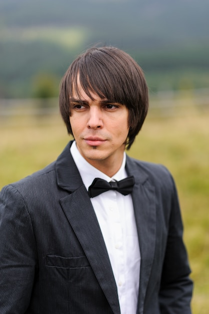 Retrato del novio en un traje. Rodada en las montañas.