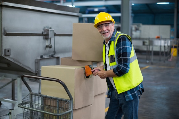 Retrato de obrero cargando cajas de cartón