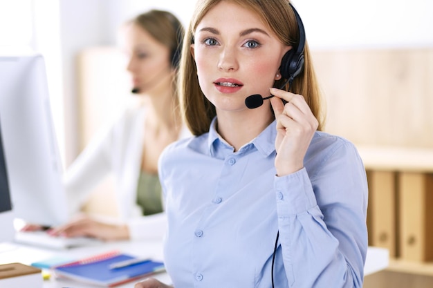 Retrato del operador del centro de llamadas en el trabajo. Grupo de personas con auriculares listos para ayudar a los clientes. Concepto de negocio.