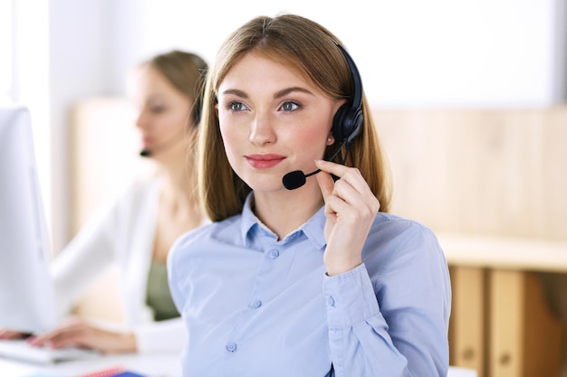 Retrato del operador del centro de llamadas en el trabajo. Grupo de personas con auriculares listos para ayudar a los clientes. Concepto de negocio.