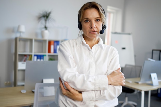 Retrato de una operadora de centro de llamadas femenina seria en auriculares