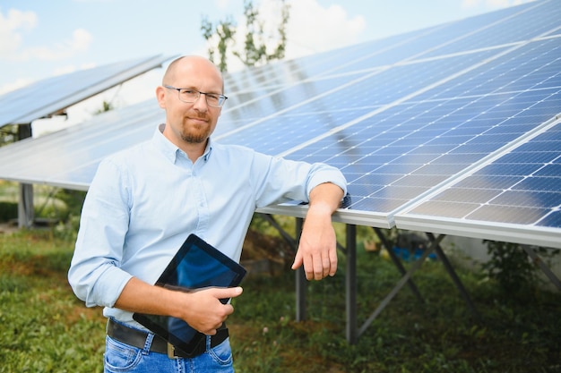 El retrato de un orgulloso ingeniero sonríe satisfecho con su exitoso trabajo. Concepto: energía renovable, tecnología, electricidad, servicio, energía verde