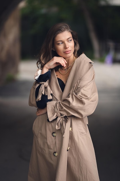 Retrato otoñal de una chica joven y bonita con un abrigo Una chica con una gabardina de moda