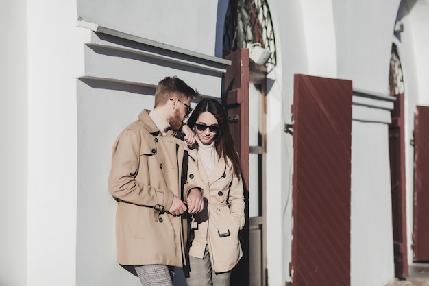 Retrato de otoño al aire libre de moda bastante joven pareja vistiendo ropa de moda y gafas de sol