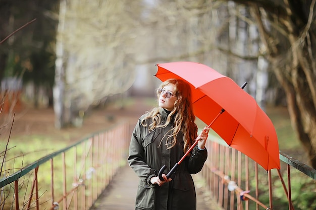 retrato de otoño estacional, chica triste con paraguas, inmunidad al virus estacional de noviembre en un paseo