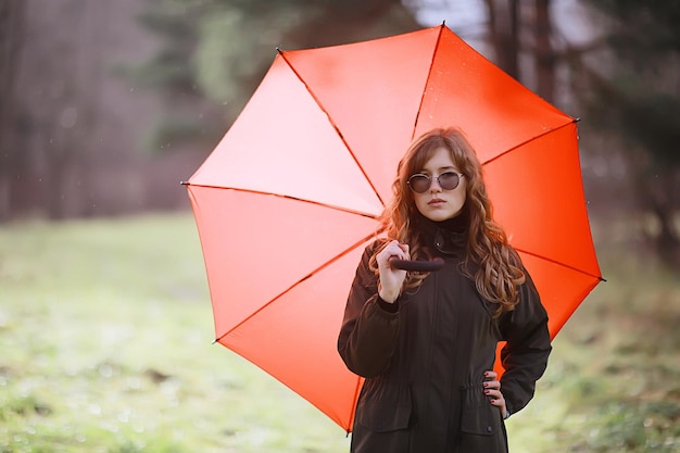 retrato de otoño estacional, chica triste con paraguas, inmunidad al virus estacional de noviembre en un paseo