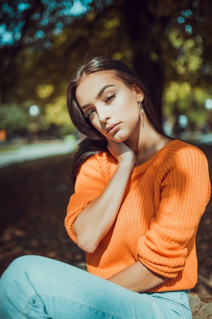 Retrato de otoño de moda joven mirando a cámara