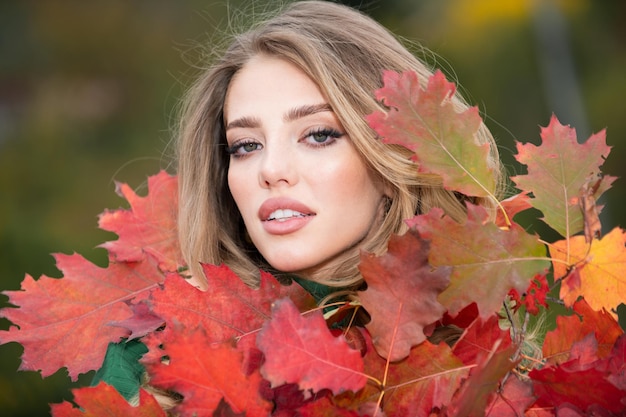 Retrato de otoño de mujer alegre con hojas de arce amarillas retrato de niña de belleza con hojas de otoño