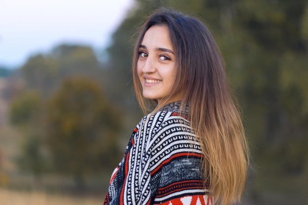 Foto retrato de otoño de una niña en suéter étnico